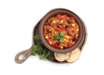 Photo of Tasty chili con carne in bowl and bread slices isolated on white, top view