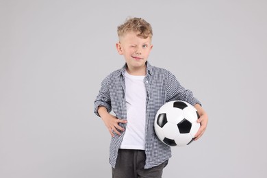 Photo of Little boy with soccer ball on gray background