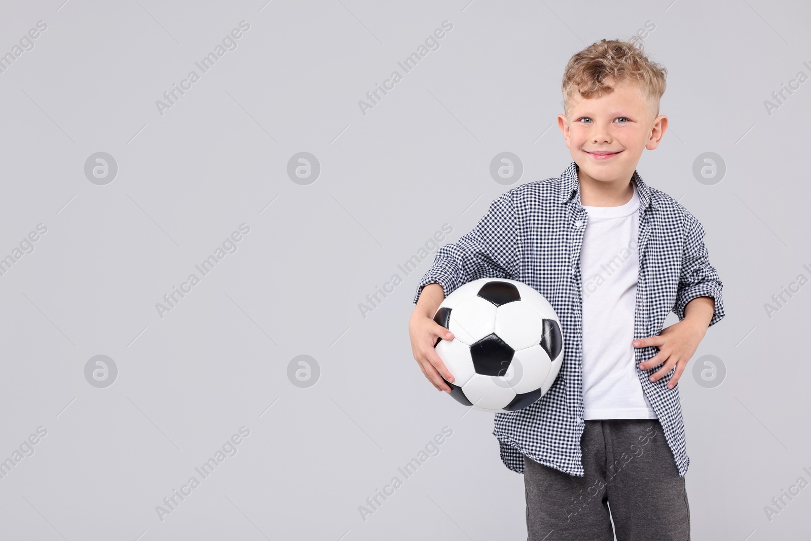 Little boy with soccer ball on gray background, space for text Photo of Little boy with soccer ball on gray background, space for text