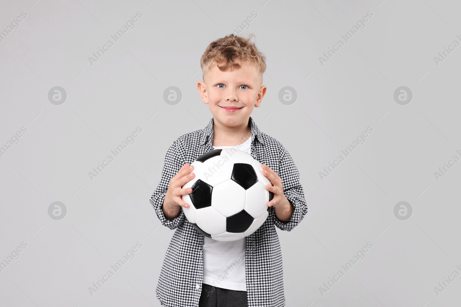 Little boy with soccer ball on gray background Photo of Little boy with soccer ball on gray background
