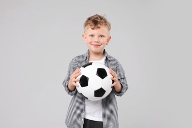 Photo of Little boy with soccer ball on gray background