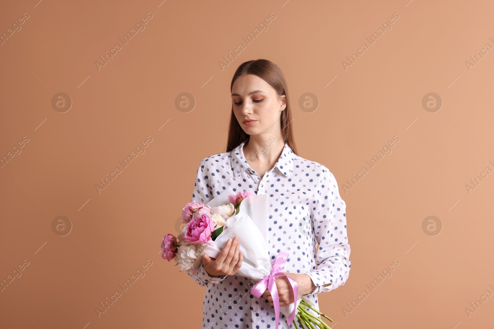 Woman with beautiful bouquet of peonies on dark beige background Photo of Woman with beautiful bouquet of peonies on dark beige background