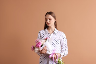 Photo of Woman with beautiful bouquet of peonies on dark beige background