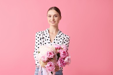 Photo of Woman with beautiful bouquets of peonies on pink background