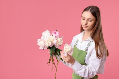 Photo of Florist with beautiful peonies on pink background, space for text