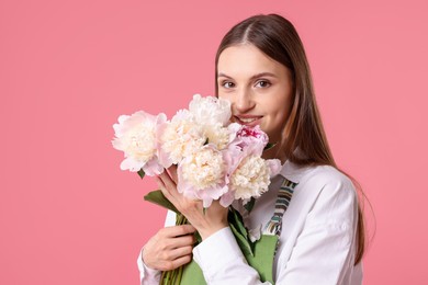 Photo of Florist with beautiful peonies on pink background