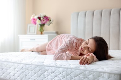 Photo of Woman sleeping on bed with orthopedic mattress at home