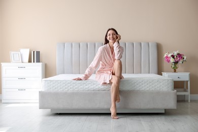 Photo of Woman on bed with orthopedic mattress at home