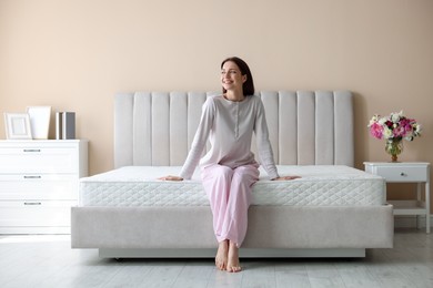 Photo of Woman on bed with orthopedic mattress at home