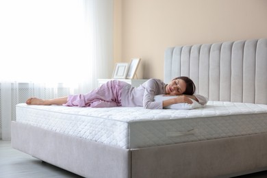 Photo of Woman sleeping on bed with orthopedic mattress at home