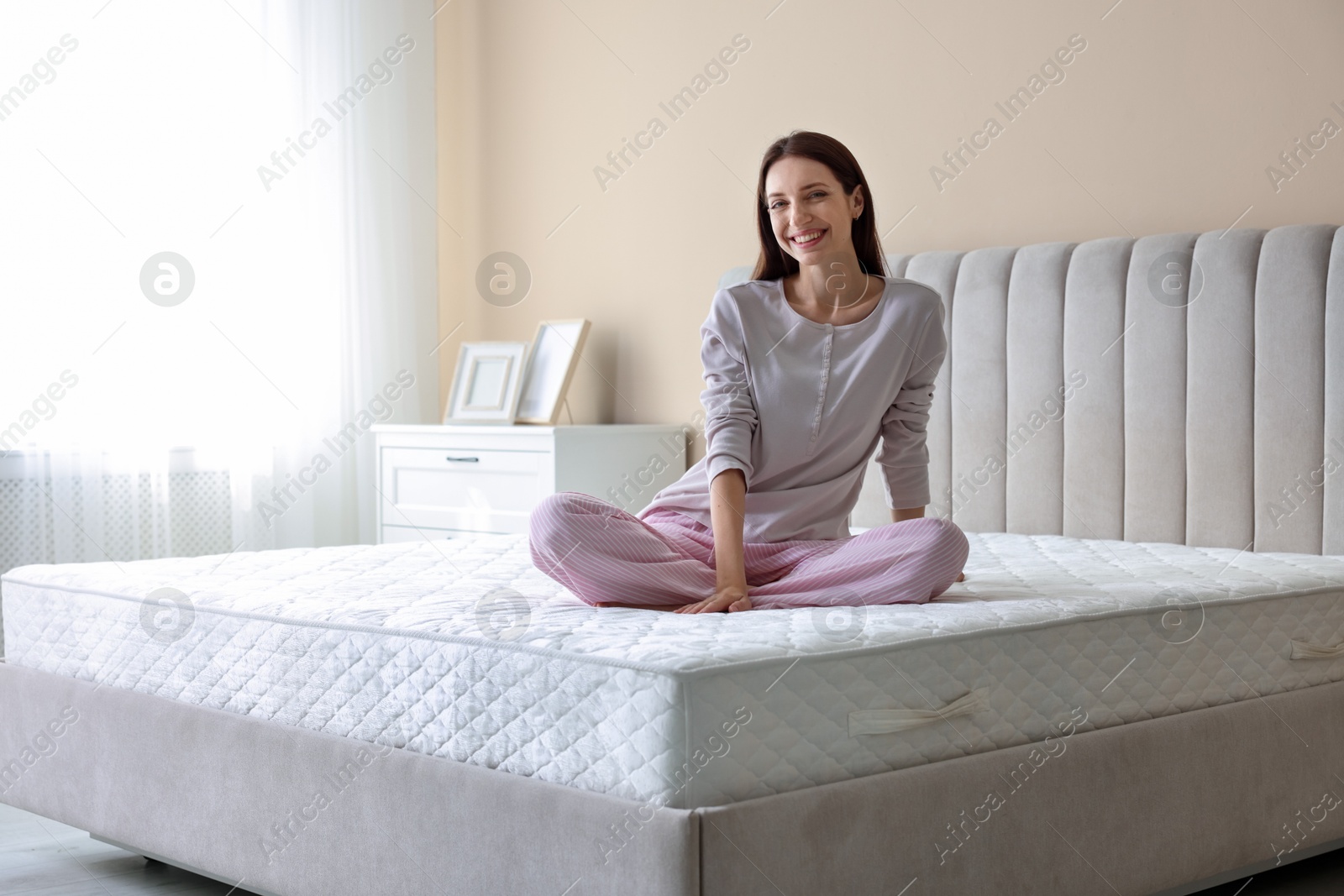 Woman on bed with soft mattress at home Photo of Woman on bed with soft mattress at home