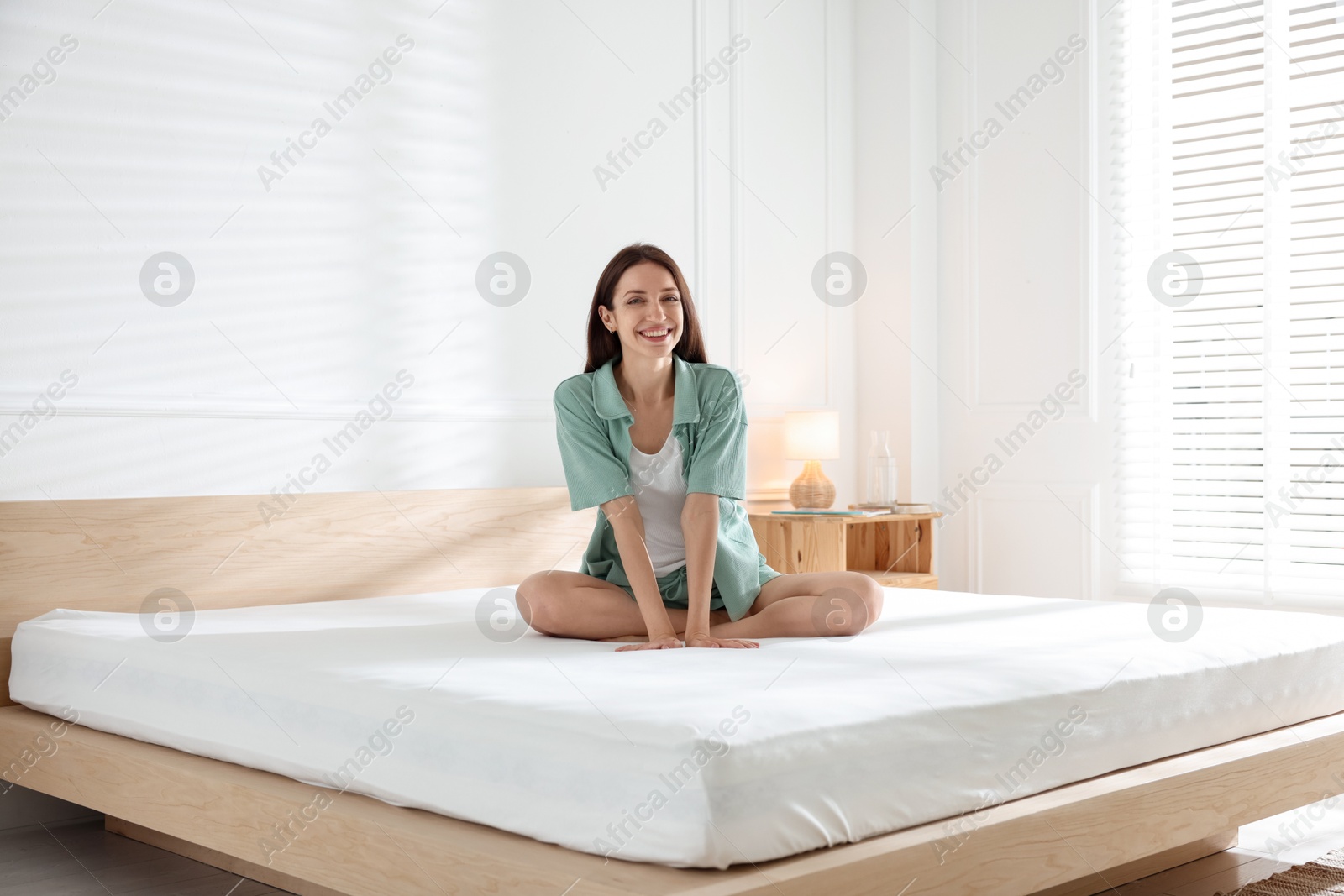 Woman on bed with soft mattress at home Photo of Woman on bed with soft mattress at home