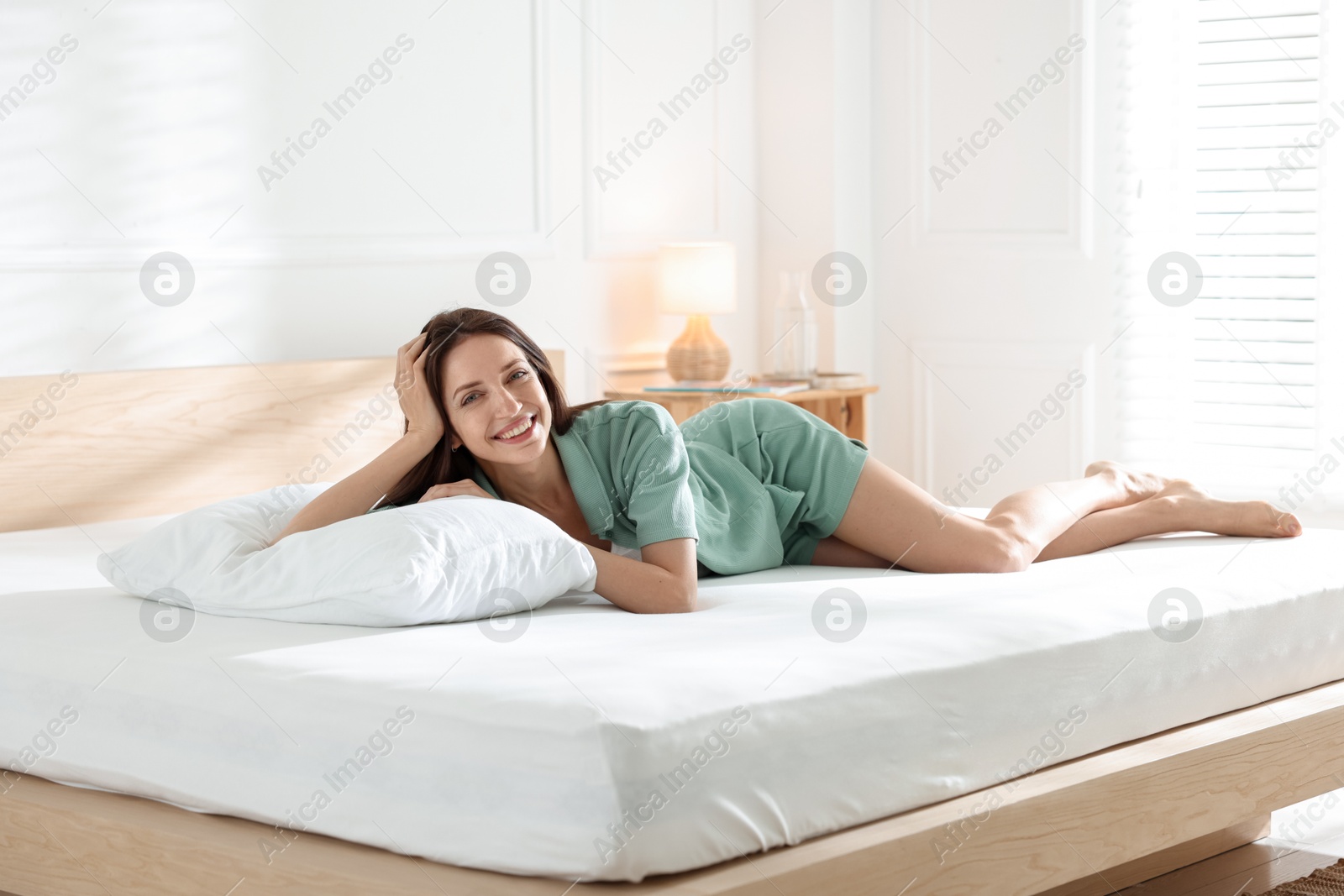 Woman lying on bed with orthopedic mattress at home Photo of Woman lying on bed with orthopedic mattress at home