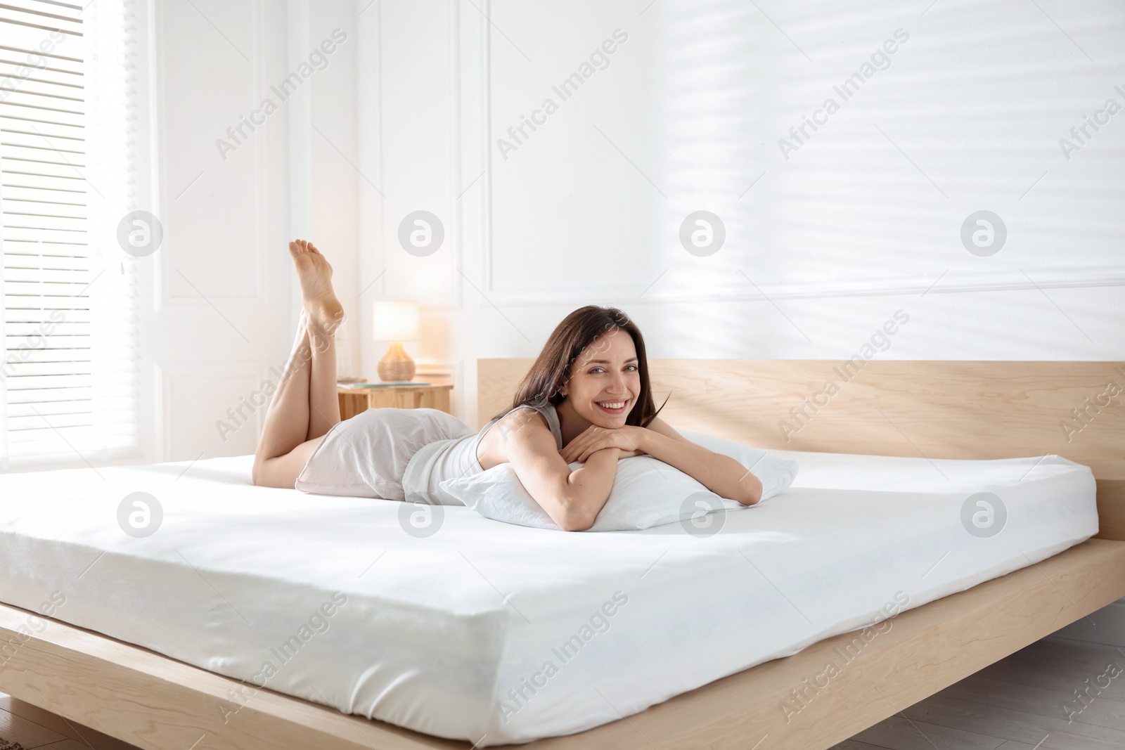 Woman lying on bed with orthopedic mattress at home Photo of Woman lying on bed with orthopedic mattress at home