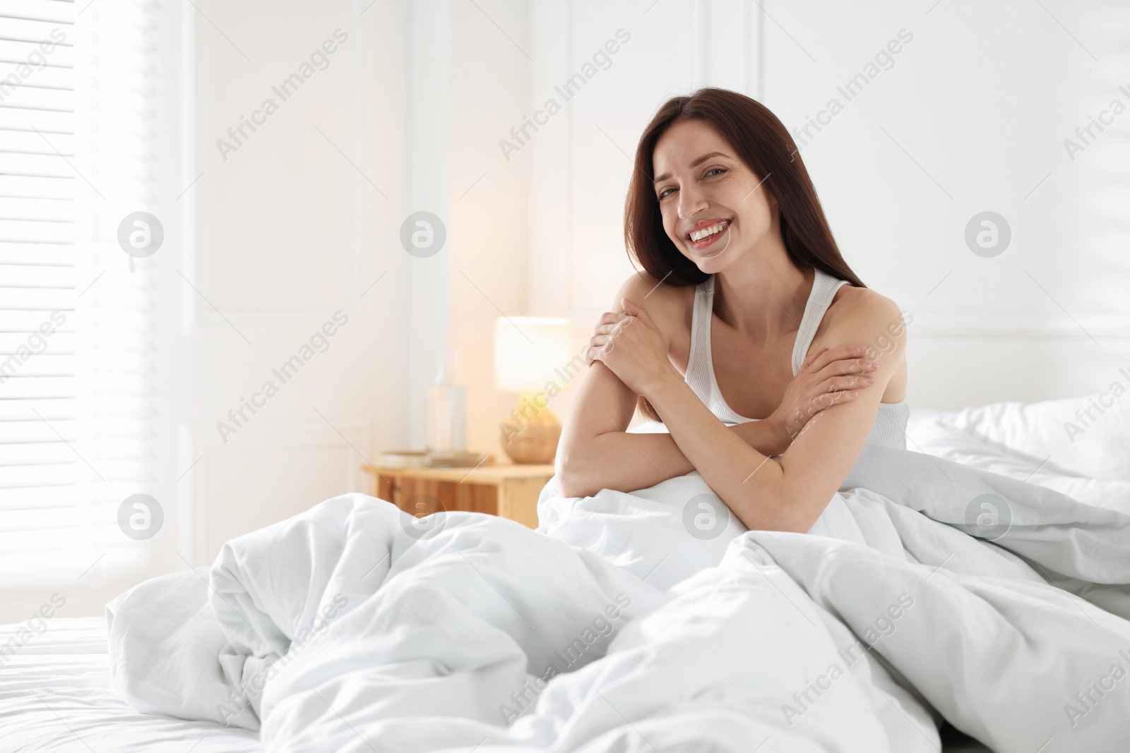 Woman on bed with soft mattress at home Photo of Woman on bed with soft mattress at home