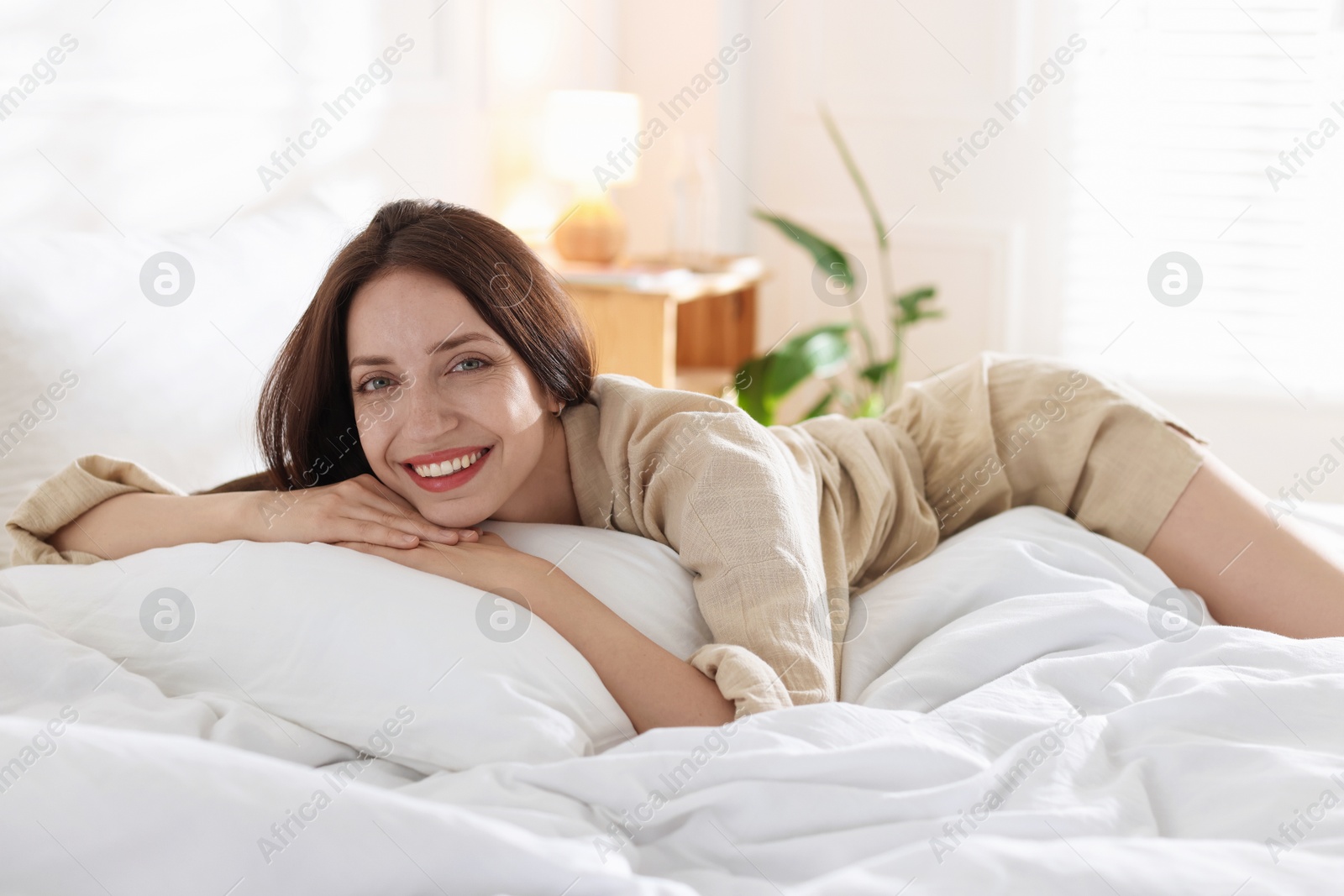 Woman lying on bed with soft mattress at home Photo of Woman lying on bed with soft mattress at home