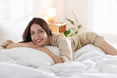 Photo of Woman lying on bed with soft mattress at home