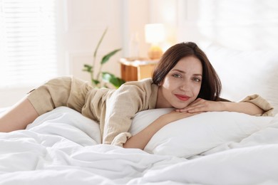 Photo of Woman lying on bed with soft mattress at home