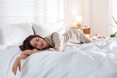 Photo of Woman sleeping on bed with soft mattress at home