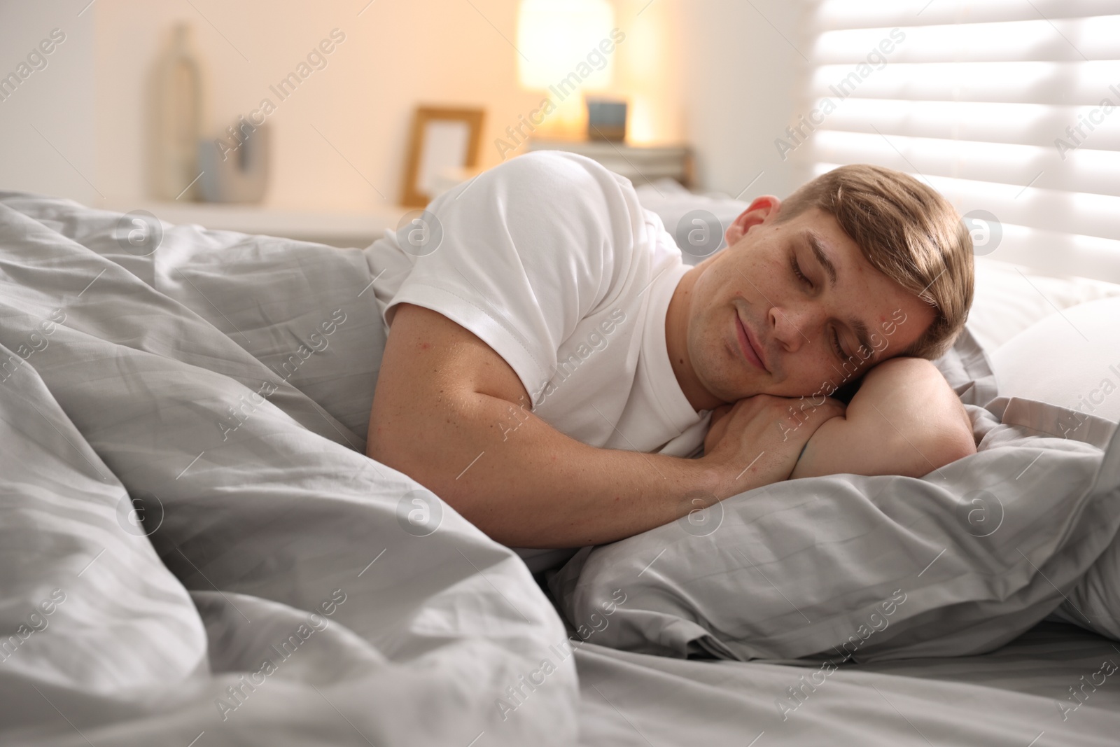 Young man sleeping on bed with soft mattress at home Photo of Young man sleeping on bed with soft mattress at home
