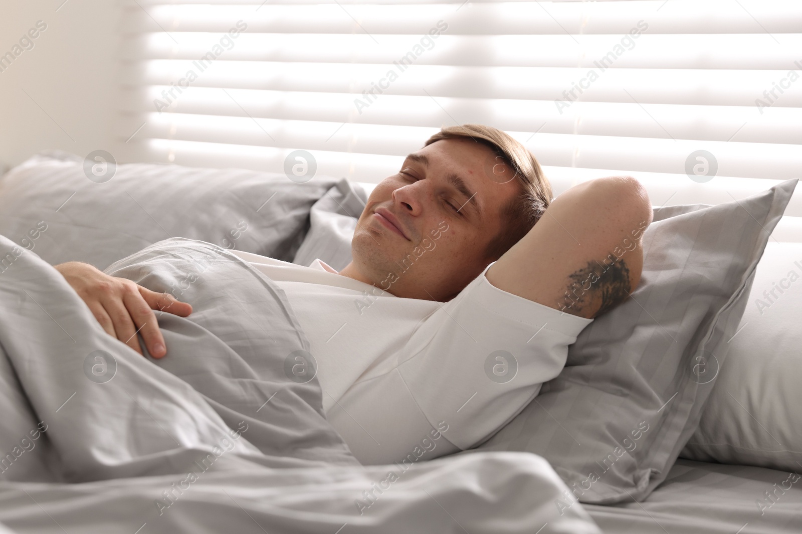Young man sleeping on bed with soft mattress at home Photo of Young man sleeping on bed with soft mattress at home