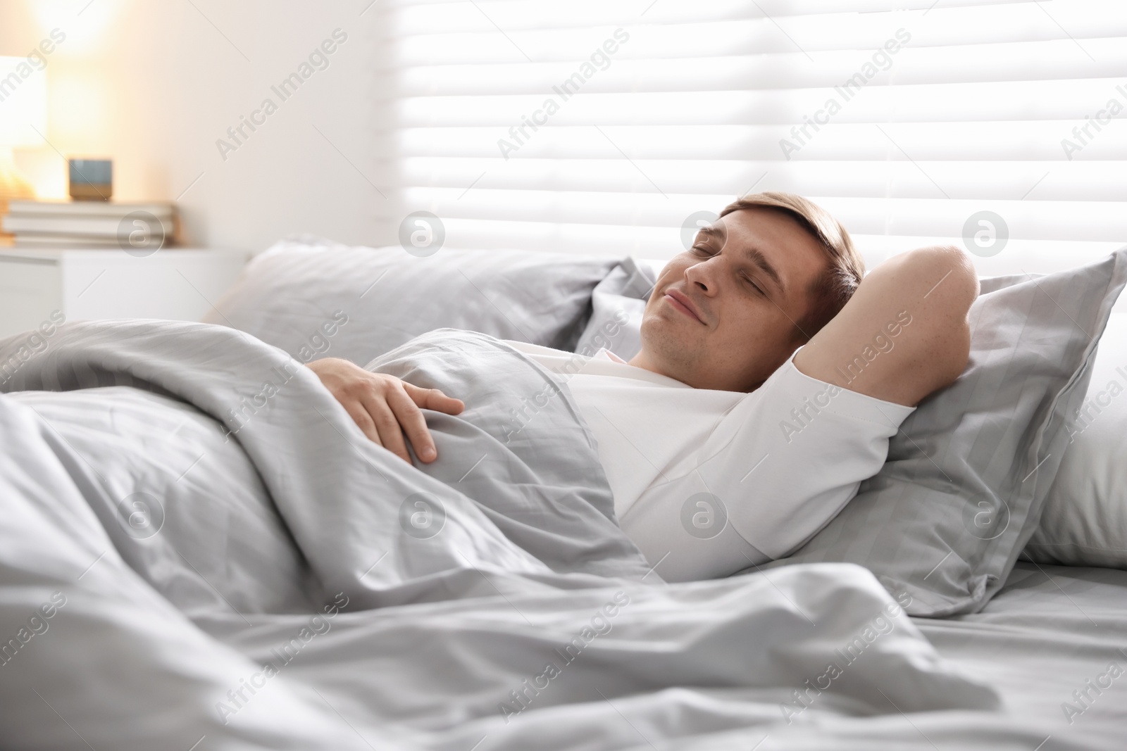 Young man sleeping on bed with soft mattress at home Photo of Young man sleeping on bed with soft mattress at home