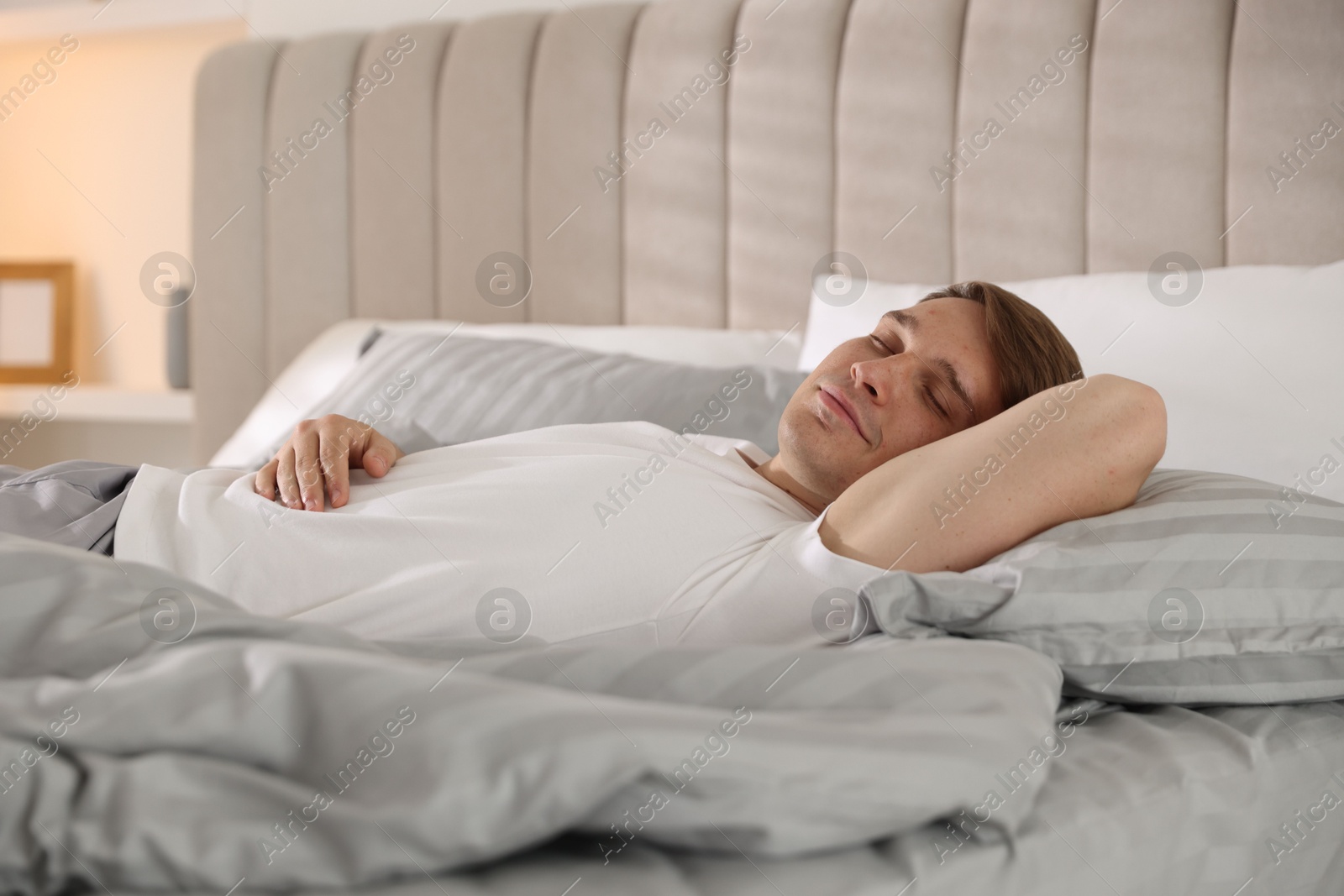 Young man sleeping on bed with soft mattress at home Photo of Young man sleeping on bed with soft mattress at home