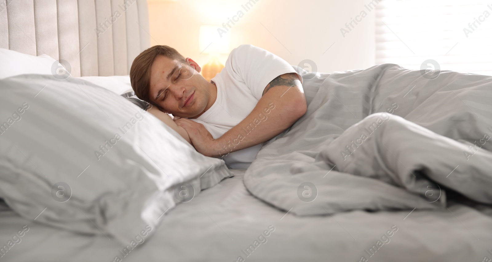 Young man sleeping on bed with soft mattress at home Photo of Young man sleeping on bed with soft mattress at home