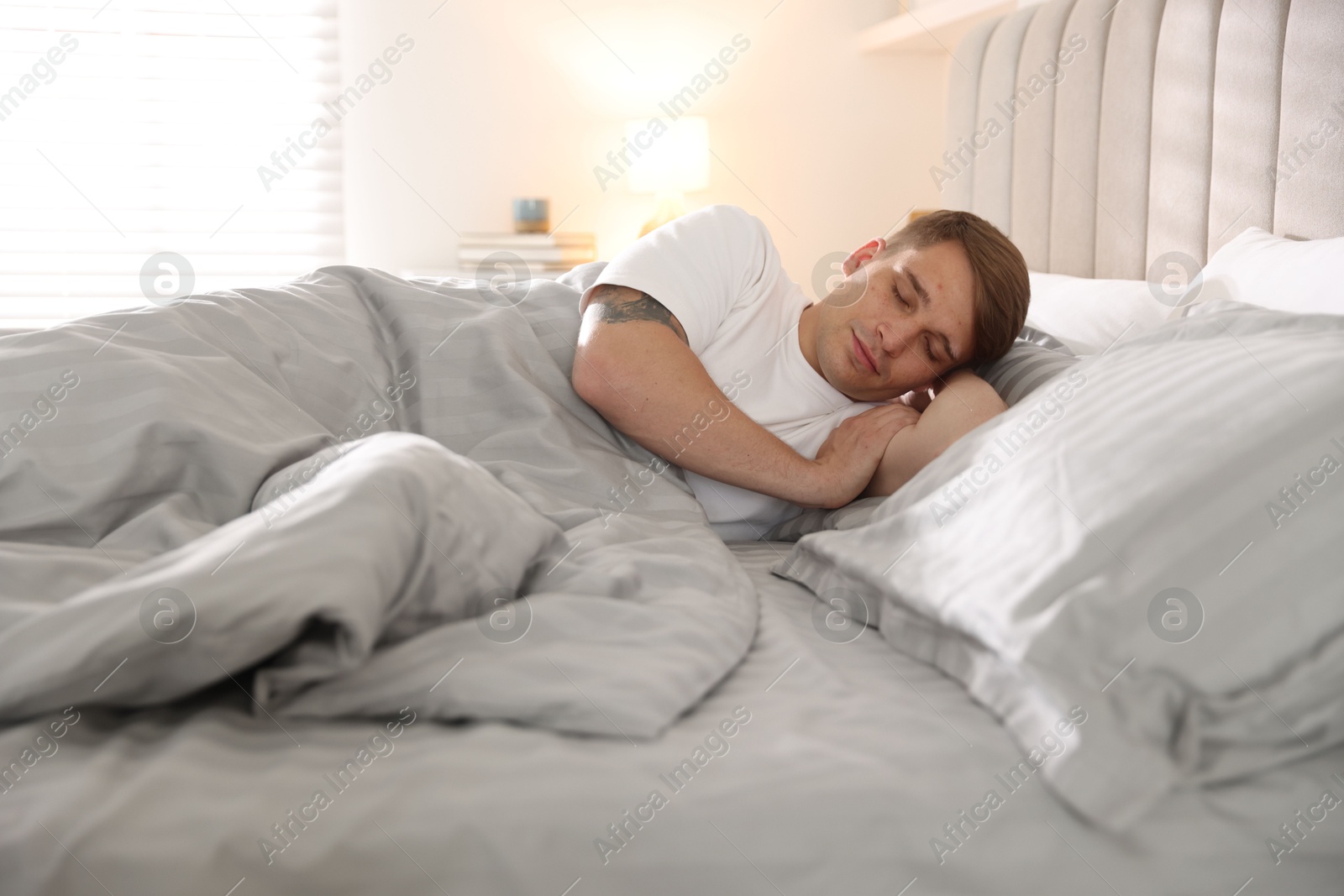 Young man sleeping on bed with soft mattress at home Photo of Young man sleeping on bed with soft mattress at home