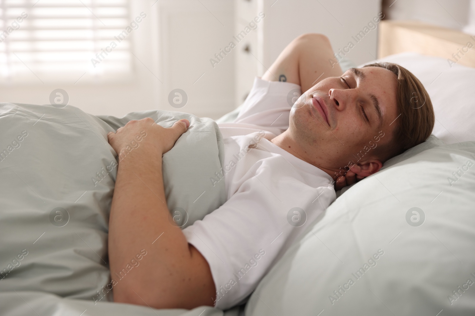 Young man sleeping on bed with soft mattress at home Photo of Young man sleeping on bed with soft mattress at home