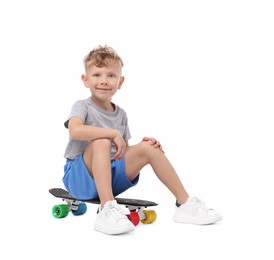 Photo of Little boy sitting on penny board against white background