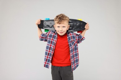 Photo of Little boy with penny board on gray background