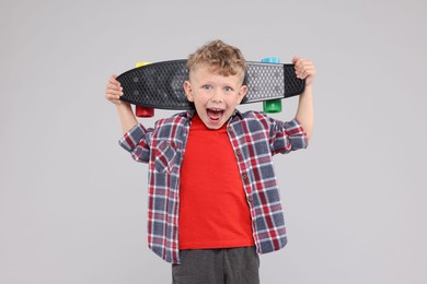 Photo of Little boy with penny board on gray background