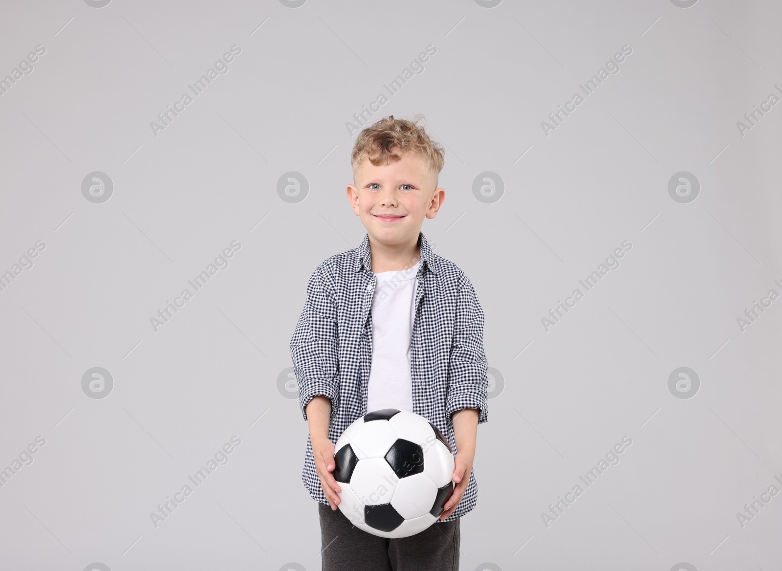 Little boy with soccer ball on gray background Photo of Little boy with soccer ball on gray background