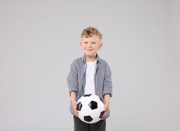 Photo of Little boy with soccer ball on gray background