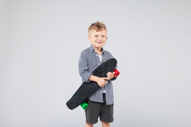 Photo of Little boy with penny board up on gray background