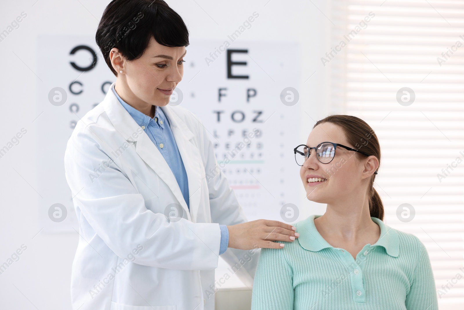 Ophthalmologist examining patient's vision with glasses in clinic Photo of Ophthalmologist examining patient's vision with glasses in clinic