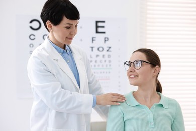 Photo of Ophthalmologist examining patient's vision with glasses in clinic