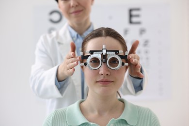 Photo of Ophthalmologist examining patient's vision with trial frame in clinic, closeup