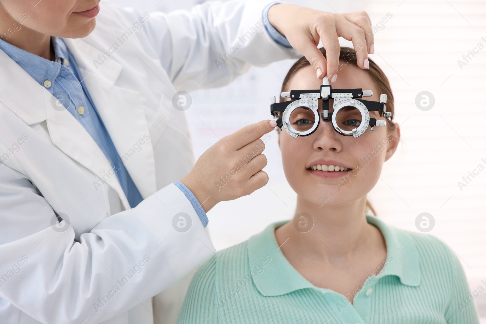 Ophthalmologist examining patient's vision with trial frame in clinic, closeup Photo of Ophthalmologist examining patient's vision with trial frame in clinic, closeup