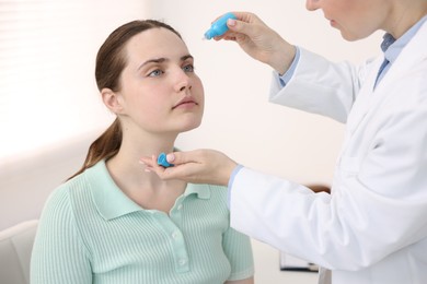 Photo of Ophthalmologist applying medical drops onto patient's eye in clinic, closeup