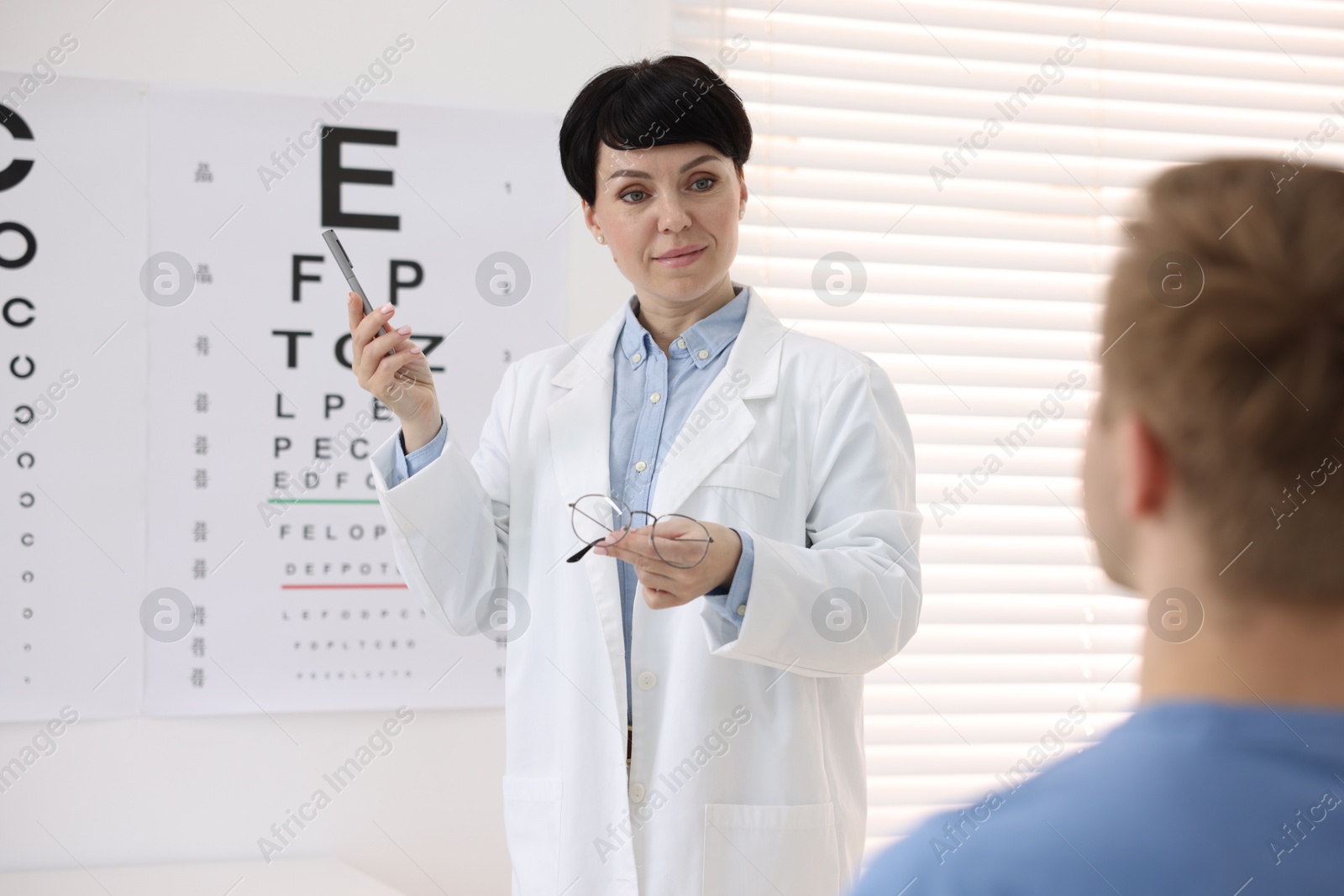 Professional ophthalmologist examining patient's vision in clinic Photo of Professional ophthalmologist examining patient's vision in clinic