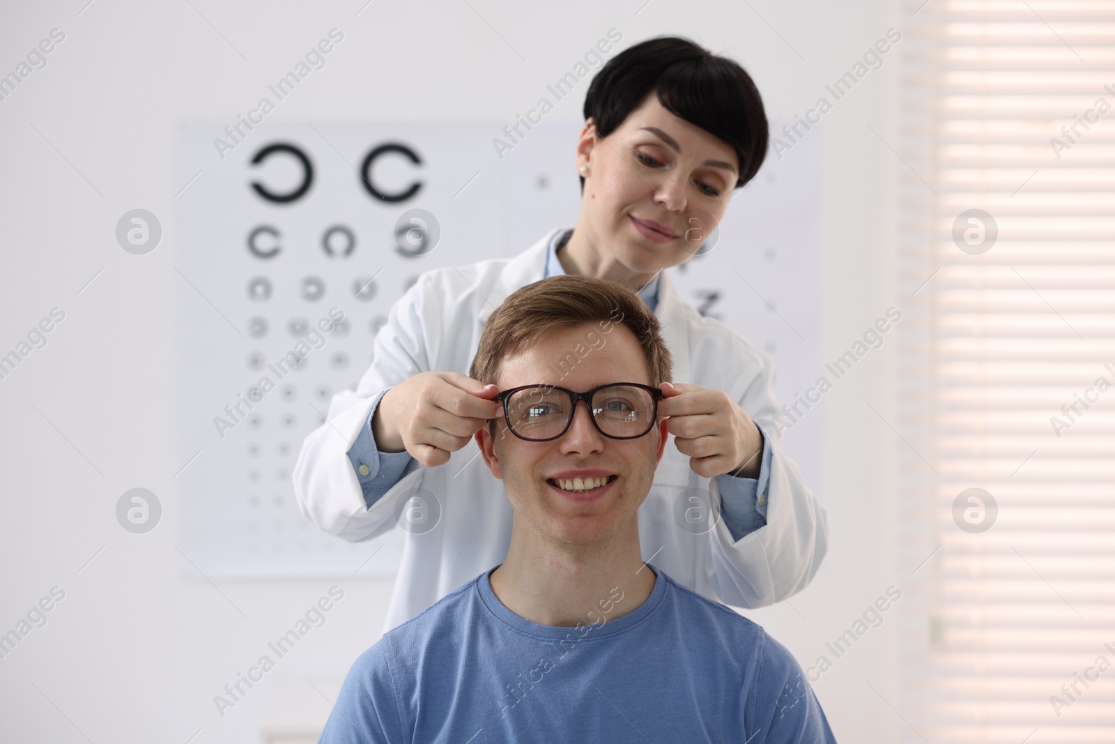 Ophthalmologist giving glasses to patient in clinic Photo of Ophthalmologist giving glasses to patient in clinic