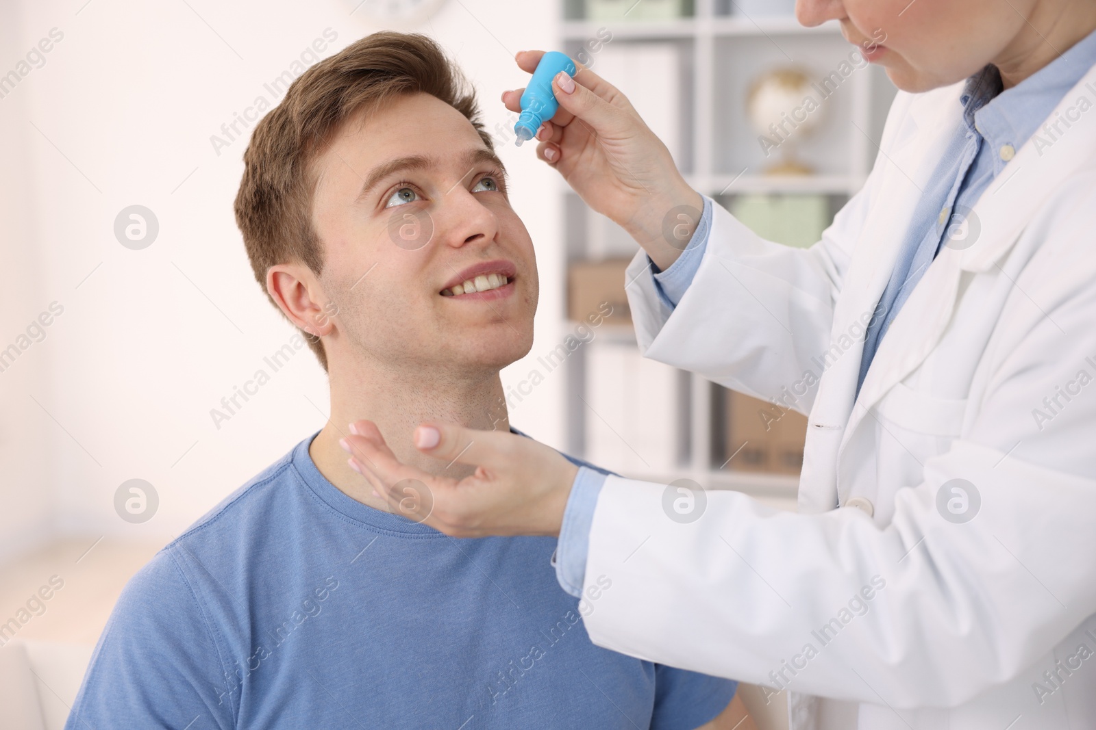 Ophthalmologist applying medical drops onto patient's eye in clinic, closeup Photo of Ophthalmologist applying medical drops onto patient's eye in clinic, closeup