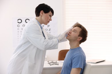 Photo of Professional ophthalmologist examining patient's vision in clinic