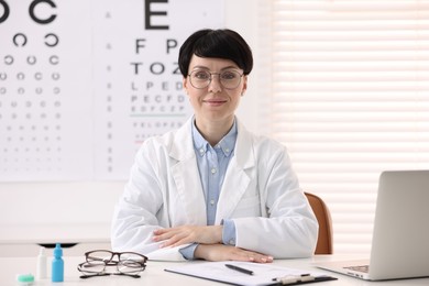 Photo of Portrait of professional ophthalmologist at white table in clinic