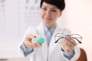 Photo of Portrait of professional ophthalmologist with glasses and contact lenses in clinic, selective focus