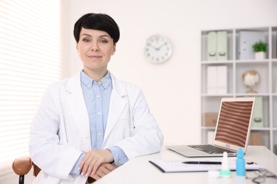 Photo of Portrait of professional ophthalmologist at white table in clinic