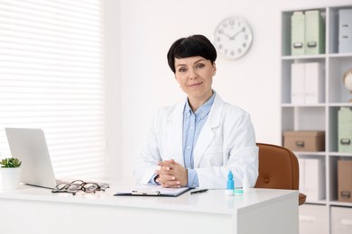 Photo of Portrait of professional ophthalmologist at white table in clinic