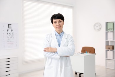 Photo of Portrait of professional ophthalmologist with crossed arms in clinic